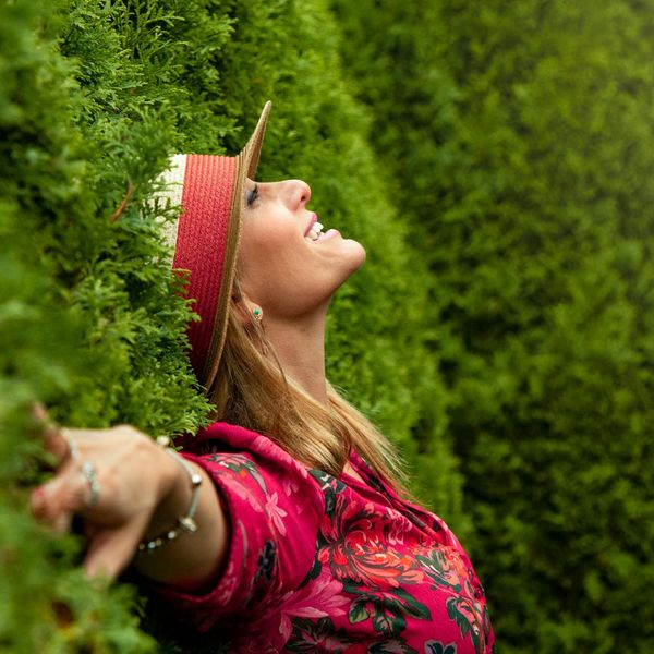 Person smiling and stretching outdoors in a green park.