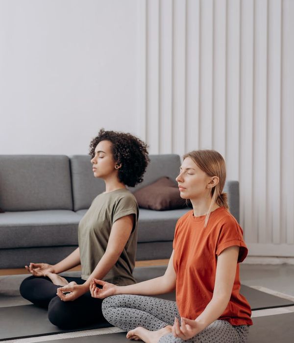 Woman in a calm yoga pose in a minimalist, bright room.